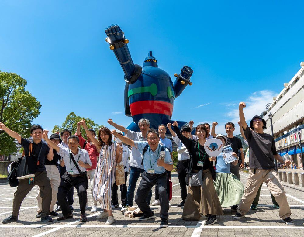 JR新長田駅前の鉄人28号と共に写真を撮るまち歩き参加者