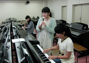 Students practicing music instruction by playing the piano and recorder